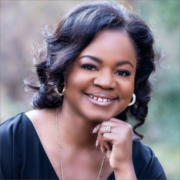 LaToya, a Black woman with black wavy hair, wears a black blouse. 