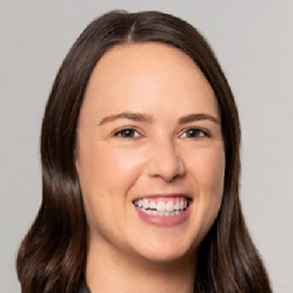 Andrea, a white woman with brown hair, wears a black blouse.