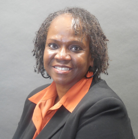 Alice, a Black woman with black hair, wears an orange button-down blouse and black blazer.