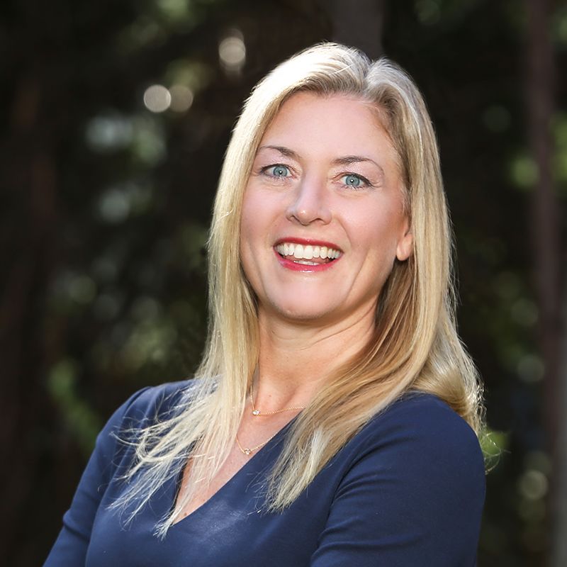 Lori, a white woman with blond hair, wears a navy blue blouse.
