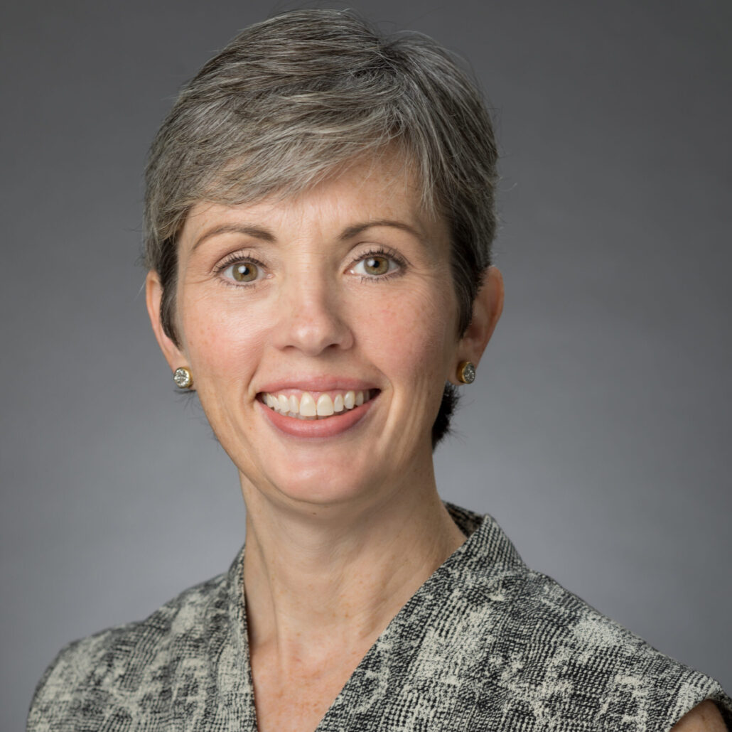 Allyn, a white woma with grey hair, wears a light grey blouse.