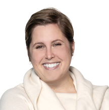 Grace, a white woman with short brown hair, wears an ivory sweater.