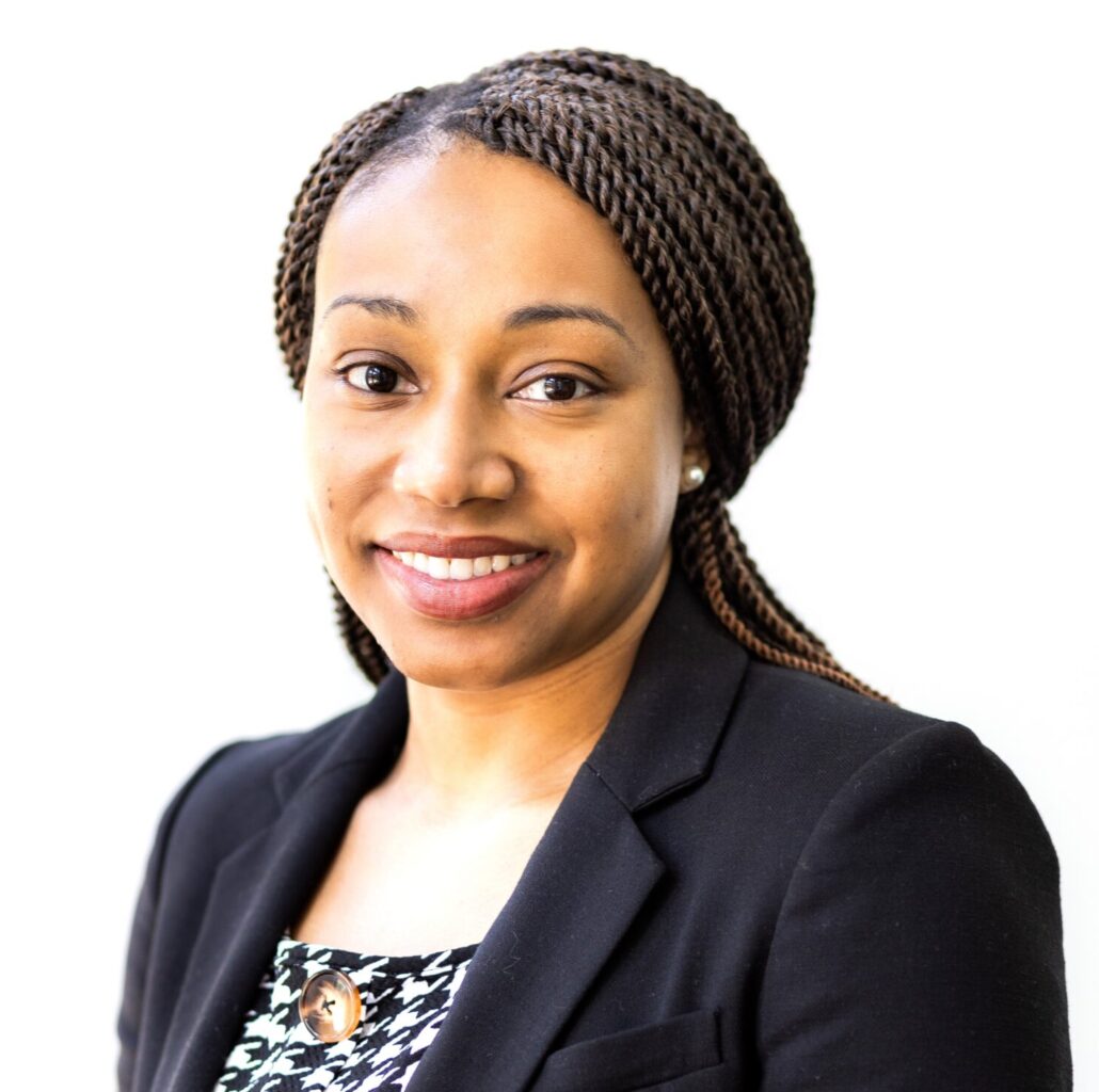 Lakethia, a Black woman with black hair, wears a black and white blouse and black blazer.
