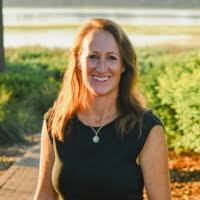 Helen, a white woman with auburn hair, wears a black dress.