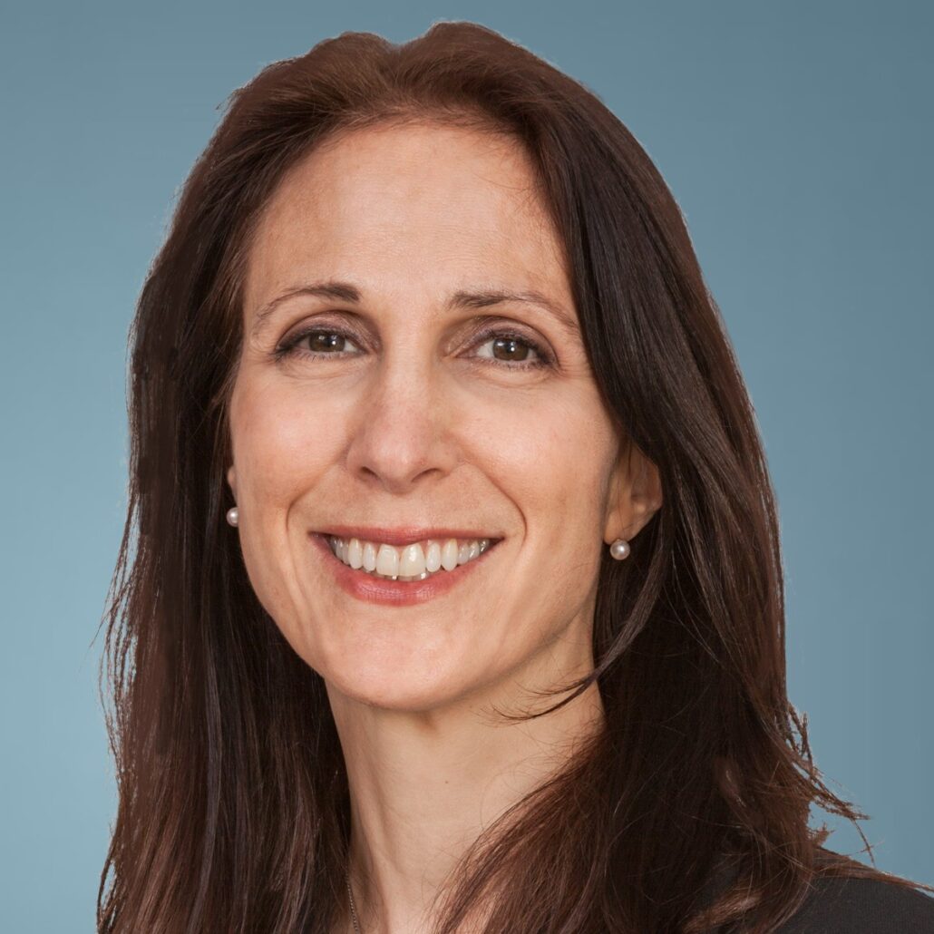 Karen, a white woman with brown eyes and brown hair, wears a black suit.