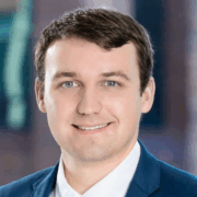 David, a white man with brown hair, wears a white shirt and navy suit.