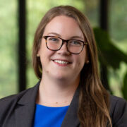 Kathrynn, a white woman with brown hair, wears a blue blouse and black jacket.