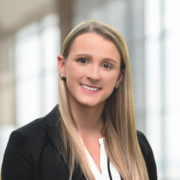 Melissa, a white woman with blond hair, wears a white blouse and black jacket.