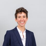 Hannah, a white woman with brown hair, wears a white shirt and black blazer.