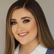 Jessica, a white woman with brown hair, wears a white shirt and blue suit.