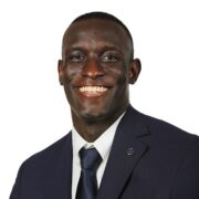 Jalen, a Black man with black hair, wears a white shirt, dark grey tie and black suit.