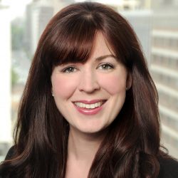 Amy, a white woman with reddish-brown hair and bangs, wears a black blouse.