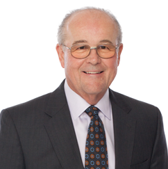 Jim, a white man with white hair, wears a white shirt and black jacket.