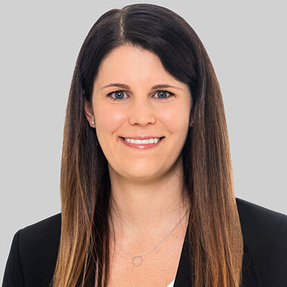 Lisa, a white woman with brown hair and blue eyes, wears a white blouse with a black jacket.