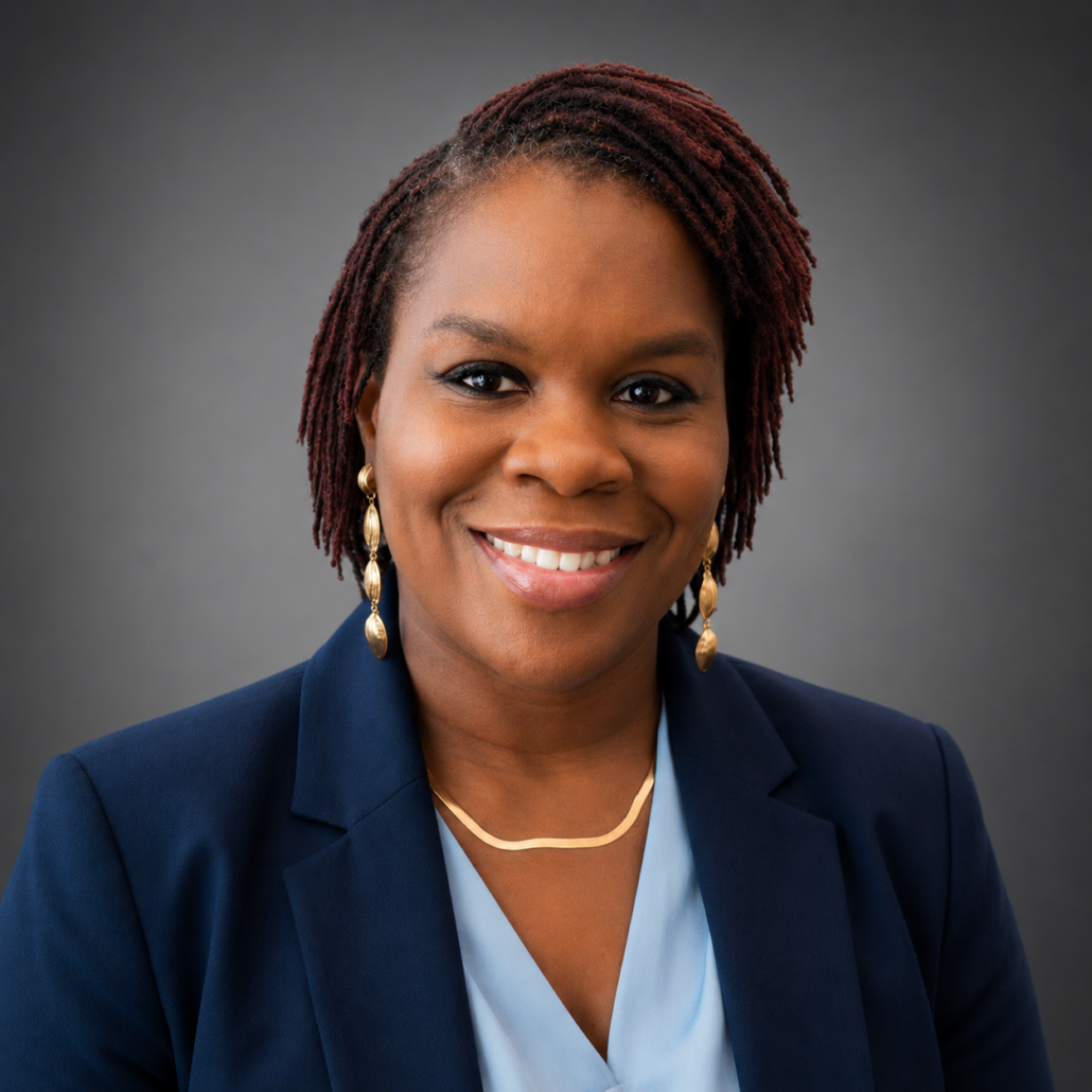 Latisha, a Black woman with black hair, wears a light blue blouse and navy suit.
