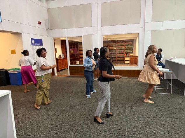 A group of MIP members is shown line dancing in the Bar Center Galleria.