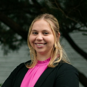 Brooke, a white woman with blond hair, wears a pink blouse and black blazer.